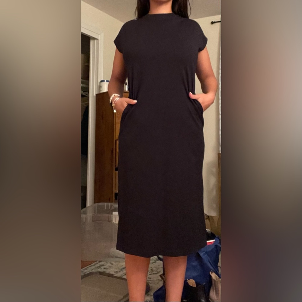 Black dress with pockets. It has a have cut in back